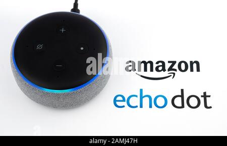 Amazon Echo Dot 3rd generation with blue lights on and device logo printed on paper. Smart speaker with Alexa assistant. Real photo, not a montage. Stock Photo