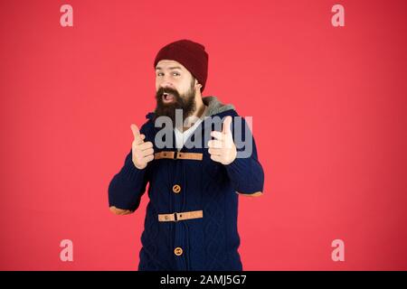 Winter menswear. Clothes design. Man bearded warm jumper and hat red background. Winter season menswear. Personal stylist. Warm and comfortable. Fashion menswear shop. Masculine clothes concept. Stock Photo