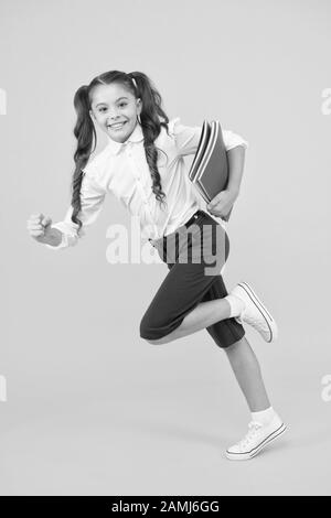 Back to school. Kid cheerful schoolgirl running. Pupil want study. Active child in motion. Beginning school lesson. Keep going. Active kid. Hurry up. Girl with books on way to school. Knowledge day. Stock Photo