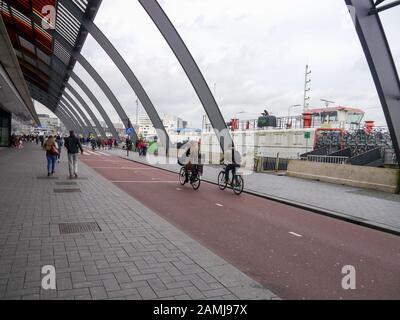 Cycles and pedestrians under the covered stained glass of Amsterdam Central Station Stock Photo