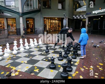 A mother and child play chess on the giant board at Max Euweplein, Amsterdam, Netherlands, Europe Stock Photo