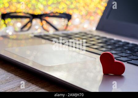 Red heart on computer keyboard soft bokeh. Internet dating, Valentines day concept with copyspace. Stock Photo