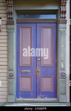 old wooden double door with elaborate wood carving and peeling paint Stock Photo