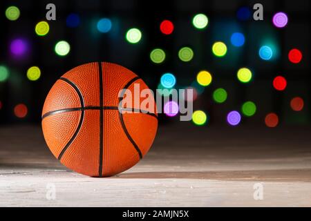 Basketball on a texture surface with defocus colourful lights on the background. Stock Photo