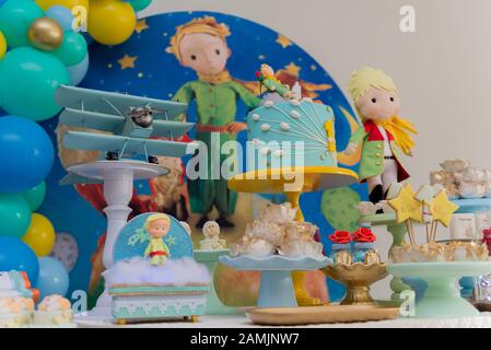 Sweet table and big cake for first birthday. Candy bar with a lot of candies, cupcakes and sweet cakes. Little prince theme party. Close up of decor p Stock Photo