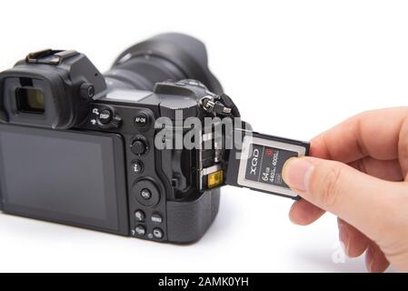 Man's hand holding XQD card on a white background. Stock Photo