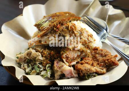 Nasi Campur Babi Guling. Balinese rice dish of roast pork with other pork and vegetable side dishes. Stock Photo