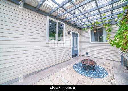Paved patio with blue wooden pergola day light Stock Photo