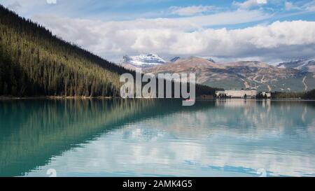 Mountain peaks, trees and Fairmont Chateau refelcted in Lake Louise, Banff National Park, Canadian Rockies Stock Photo