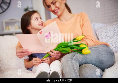 Mom and her daughter with greeting card celebrating Mother's Day Stock Photo
