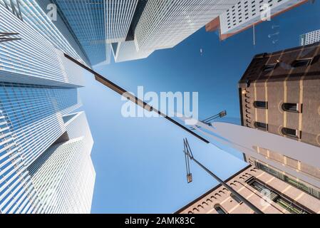 Rotterdam, Netherlands - April 18, 2019 : Ancient and modern buildings low angle view reflections in a glass building in Wilhelminapier district. Stock Photo