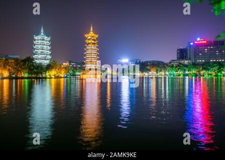 Guilin, Guangxi province, China - Nov 5, 2019 : Sun and moon pagodas illuminated at night reflecting in ShanHu lake Stock Photo