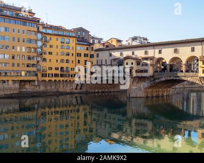 FLORENCE, ITALY, January 6, 2020: The River Arno in winter sunshine. Ponte Santa Trinita bridge looking to San Frediano in Cestello church in the Stock Photo