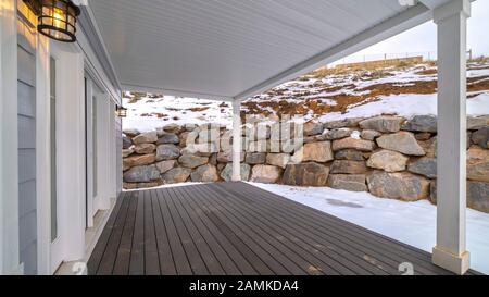 Panorama frame Wooden exterior deck and retaining stone wall Stock Photo