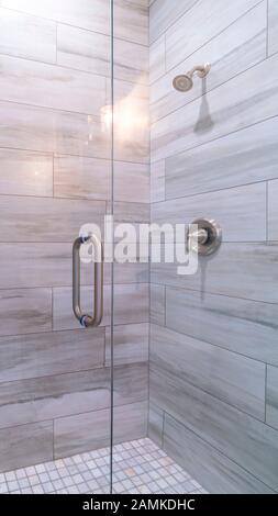 Vertical frame Large modern tiled shower cubicle bright interior Stock Photo