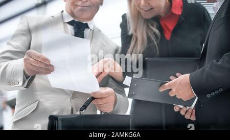 businesswoman discussing with colleagues and working papers Stock Photo