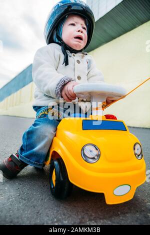 upset baby sitting in a car and crying Stock Photo