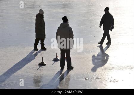 Leisure sportsmen and women at curling on the frozen Nymphenburg Castle Canal. [automated translation] Stock Photo