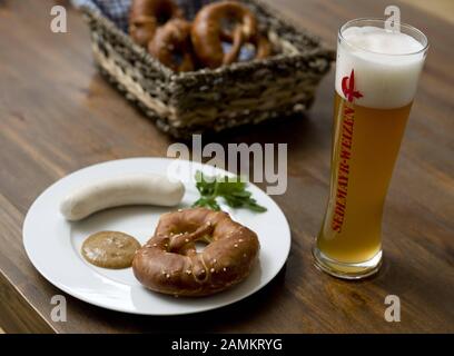 Bavarian snack with white sausage, parsley, pretzel, sweet mustard and a wheat beer. [automated translation] Stock Photo