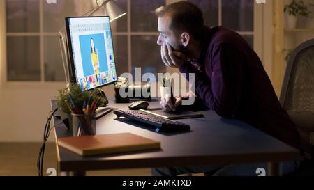 Unhappy photographer while retouching photos. Creative young artist. Stock Photo