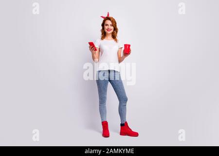 Full length body size view of her she nice attractive cheerful cheery girl holding in hand punch cup drinking beverage using 5g spending free time Stock Photo
