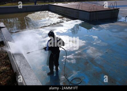 An employee of Stadtwerke München (SWM) is cleaning a swimming pool in the Maria Einsiedel outdoor pool in Thalkirchen with a high-pressure jet. [automated translation] Stock Photo