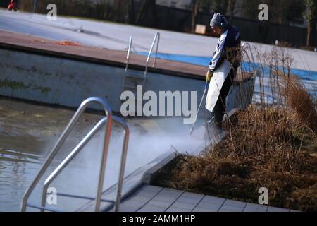 An employee of Stadtwerke München (SWM) is cleaning a swimming pool in the Maria Einsiedel outdoor pool in Thalkirchen with a high-pressure jet. [automated translation] Stock Photo