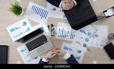Hands of anxious company managers waiting for phone call from partner, top view Stock Photo