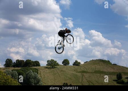 BMX cyclists during a jump in the air in front of the Olympic mountain at the extreme sports spectacle 'Munich Mash' in the Munich Olympic Park. [automated translation] Stock Photo