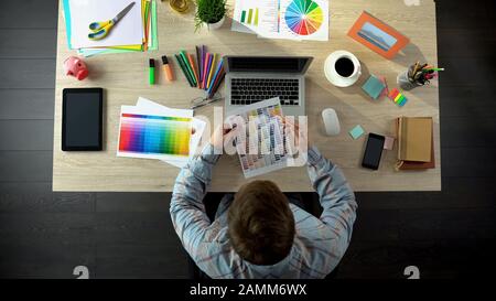 Interior designer choosing color on palette and ordering it online, top view Stock Photo
