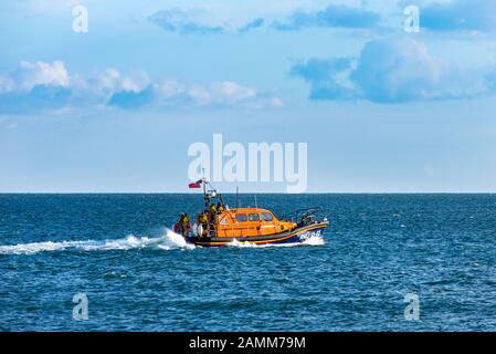 EXMOUTH, DEVON, UK - 3APR2019: RNLB R & J Welburn, a Shannon Class lifeboat, moving away from the beach, during a regular exercise. Stock Photo