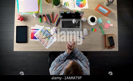 Top view of man looking for startup ideas, writing on paper and crumpling it Stock Photo