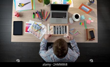 Excited man writing idea on blackboard, full of inspiration to begin working day Stock Photo