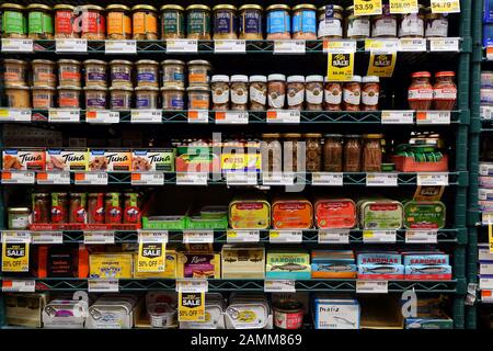 Different brands of fancy canned tuna fish, anchovies, and sardines at a gourmet market Stock Photo