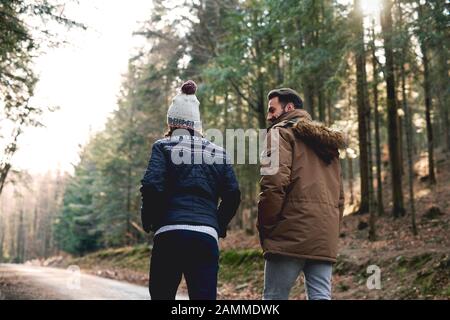 Rear view of father and son walking in autumn forest Stock Photo