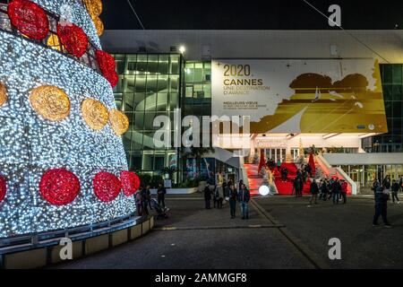 Cannes France, 28 December 2019 : Part of illuminated Christmas tree and tourists on festival red carpet stairs and 2020 board in Cannes France Stock Photo