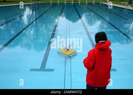 Final preparations for the start of the 2018 outdoor swimming season in Munich's Schyrenbad. An employee of the municipal utility cleans the polluted pools after the strong winds with a remote-controlled pool vacuum cleaner. [automated translation] Stock Photo