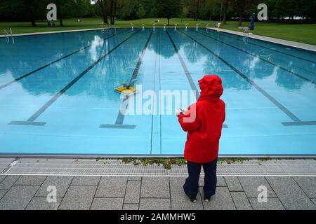 Final preparations for the start of the 2018 outdoor swimming season in Munich's Schyrenbad. An employee of the municipal utility cleans the polluted pools after the strong winds with a remote-controlled pool vacuum cleaner. [automated translation] Stock Photo