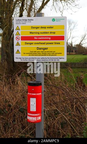 An Environment Agency warning sign and throwing line by the River Ant on the Norfolk Broads at Ludham Bridge, Norfolk, England, UK, Europe. Stock Photo