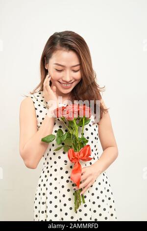 Beautiful woman holding bouquet of roses. Smiling and looking at camera. Front view Stock Photo
