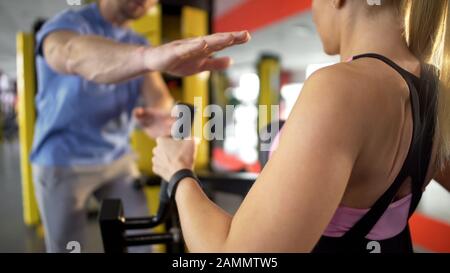 Personal trainer encouraging client and inspiring her to continue doing exercise Stock Photo
