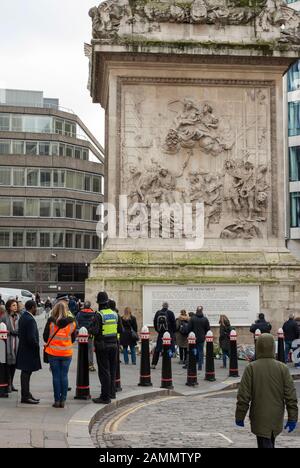 London, United Kingdom. 12 January 2020. People waiting for a religious service, commemoration and the tributes removal ceremony at the Monument for the 29 November 2019 London Bridge attack victims. Flowers laid at The Monument will be composted and will be available to the families of the victims. Stock Photo