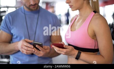 Sporty woman synchronizing schedule online with her coach to work out more often Stock Photo