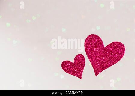 two red hearts on bright hearts bokeh background, valentines day concept design with copy space text, card template Stock Photo
