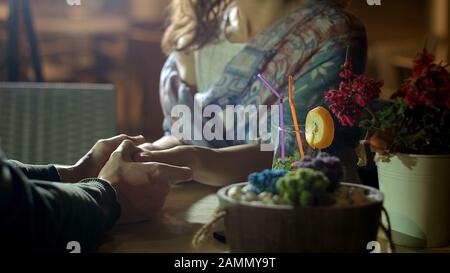 Couple holding hands tenderly, showing romantic feelings on date, love story Stock Photo