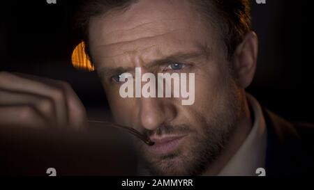 Businessman looking attentively at computer screen, thinking about report Stock Photo