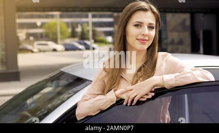 Pretty lady enjoying car present and posing for camera, happy woman and auto Stock Photo