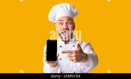Excited Chef Man Showing Smartphone Screen Posing, Studio Shot, Panorama Stock Photo