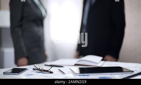 Colleagues communicating standing in office, business partners discussing deal Stock Photo