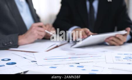 Business partners exchanging ideas about market development, using tablet pc Stock Photo